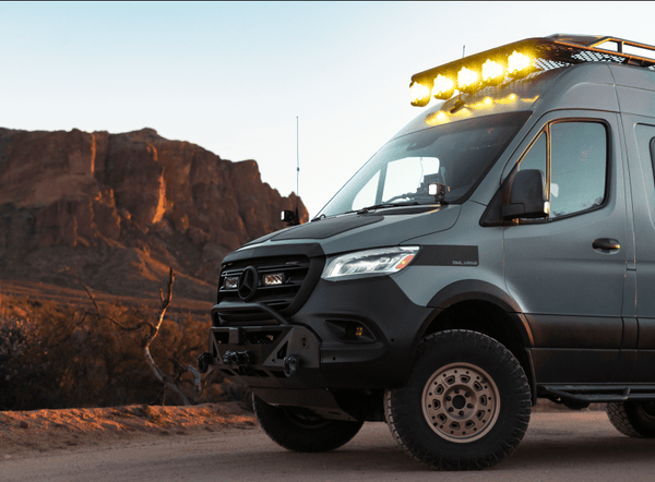 Off-road camper van parked near rocky cliffs in Moab, Utah for dispersed camping on BLM land.