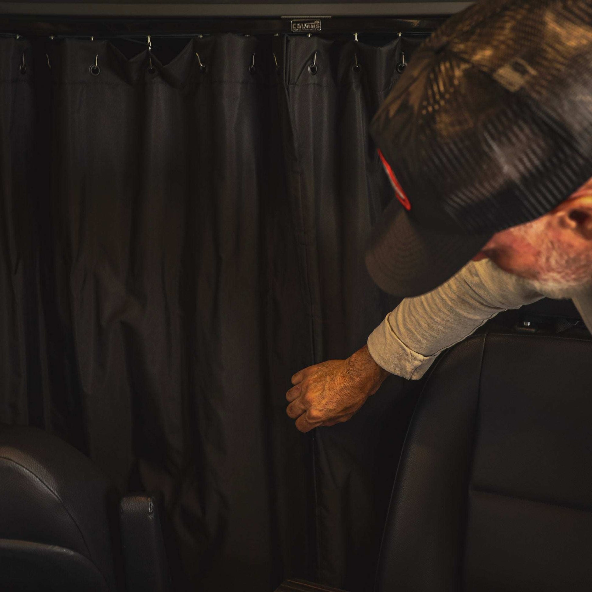 Black dual-layer insulated Sprinter Curtain with magnetic tabs for temperature control and privacy between cab and living space.