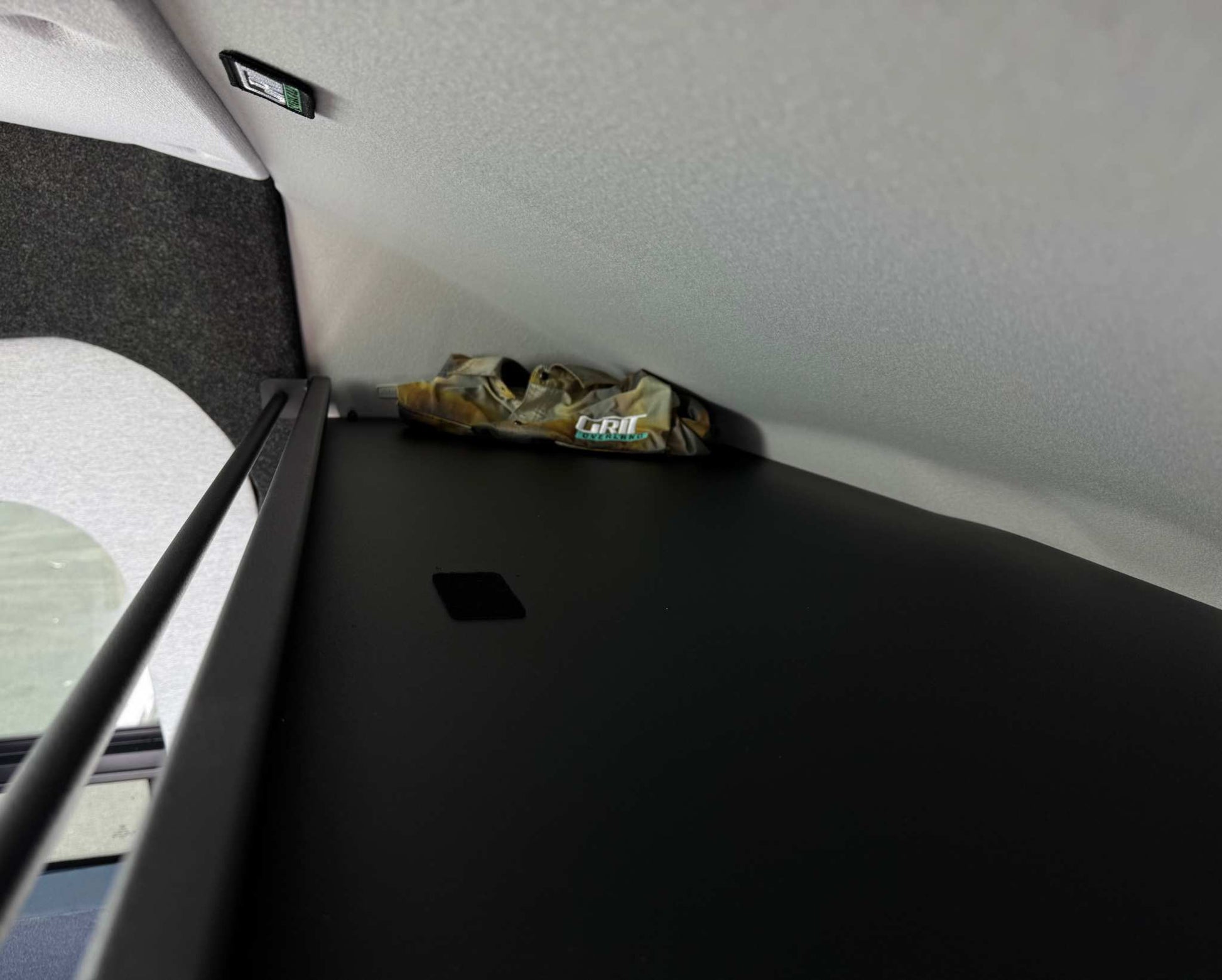 Transit headliner shelf with curtain rod installed inside van for durable and clean storage solution