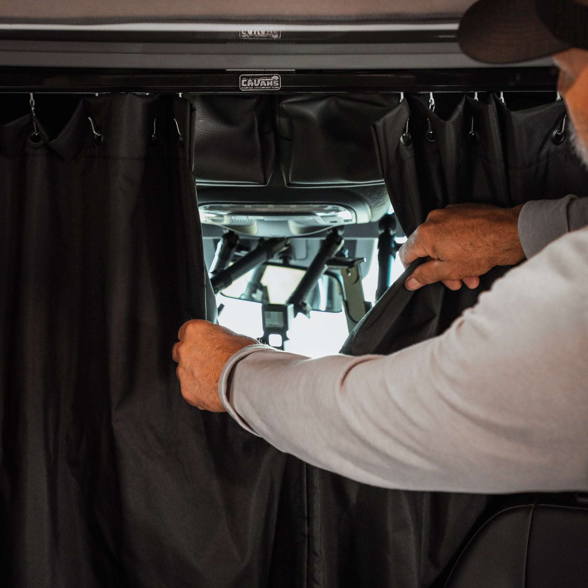 Black insulated Sprinter curtain with magnetic tabs for cab and living space separation in a van