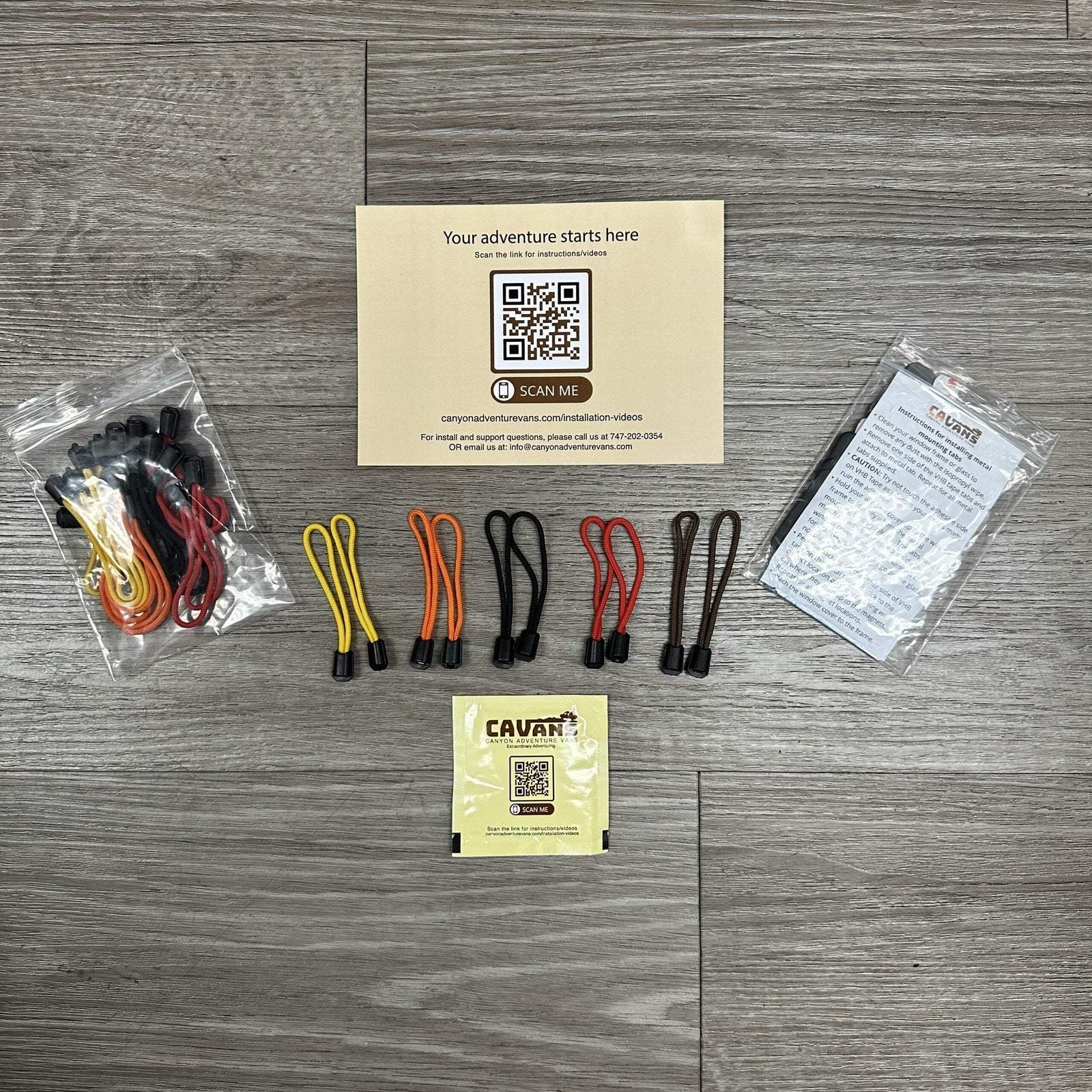 Sprinter Rear Window Covers CLIMA-SHADE insulated kit with color-coded bungee cords and installation instructions on wooden floor