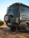 Medium Expedition Cargo Box mounted on rear of rugged off-road van with spare tire and ladder accessory