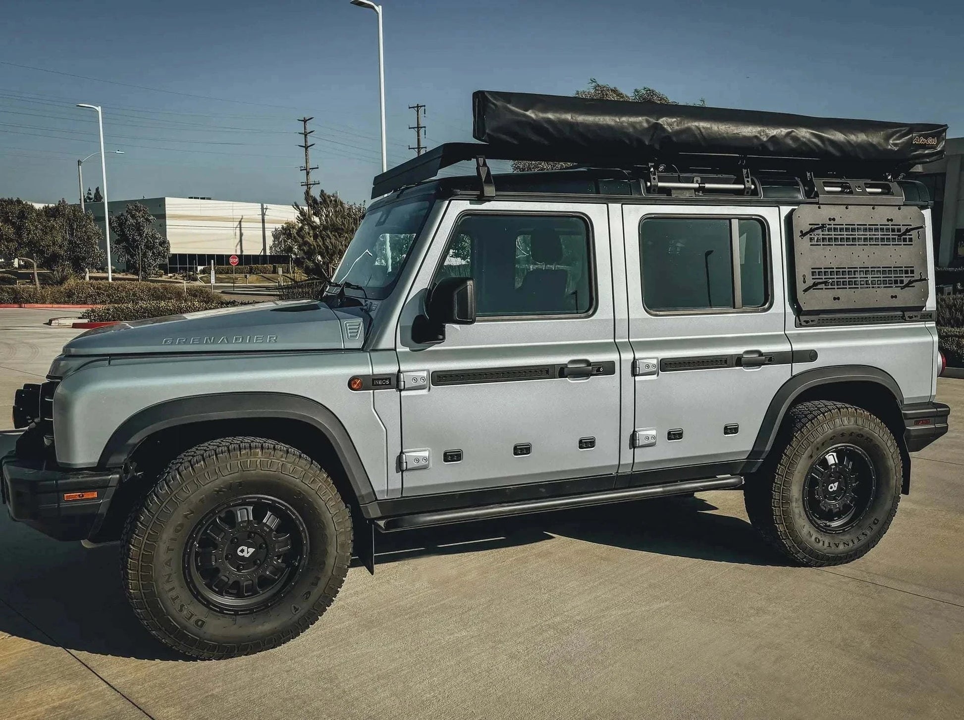 Silver INEOS Grenadier with Leitner Designs Side Kick Grenadier Accessory Panel mounted on the rear side for off-road utility and durability