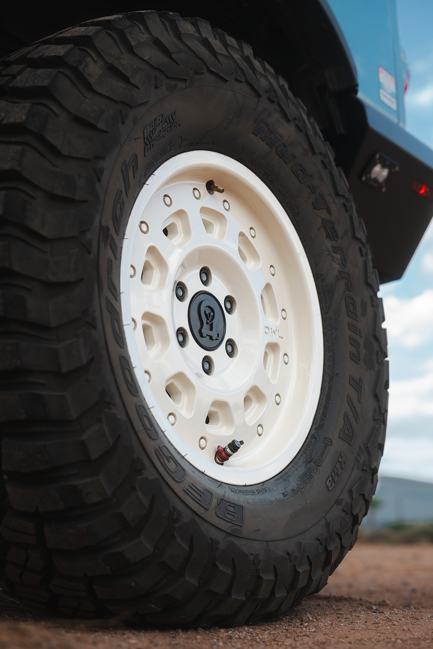 Lightweight ultra-strong aluminum Grenadier wheel with rugged off-road tire mounted on blue INEOS vehicle