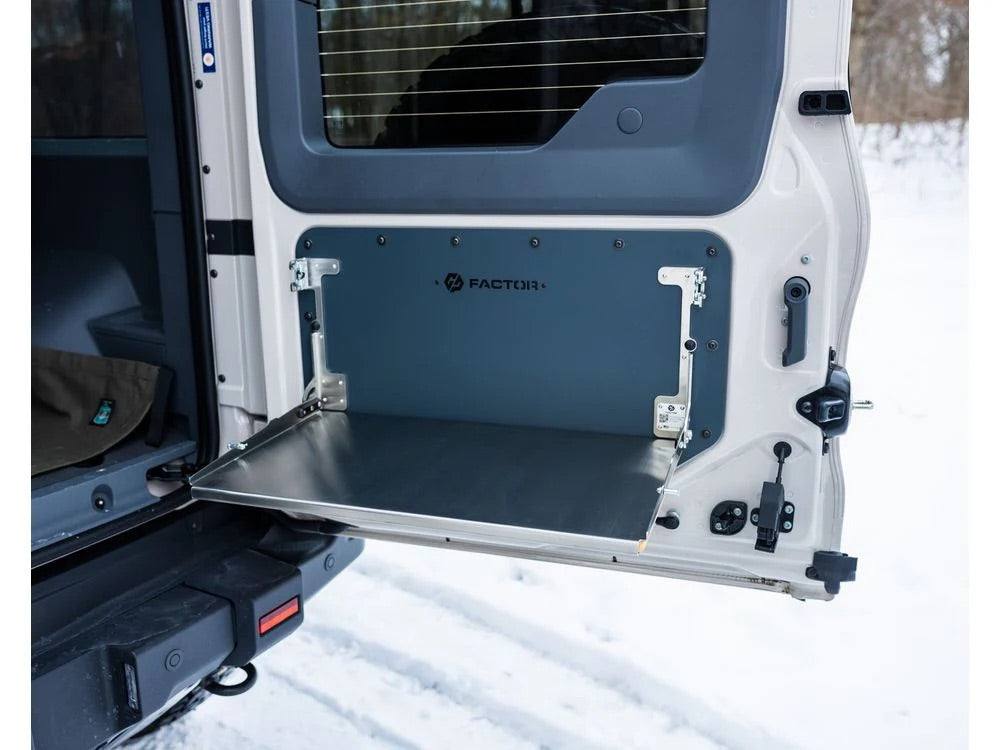 Folding tailgate table mounted on INEOS Grenadier vehicle door in snowy outdoor setting