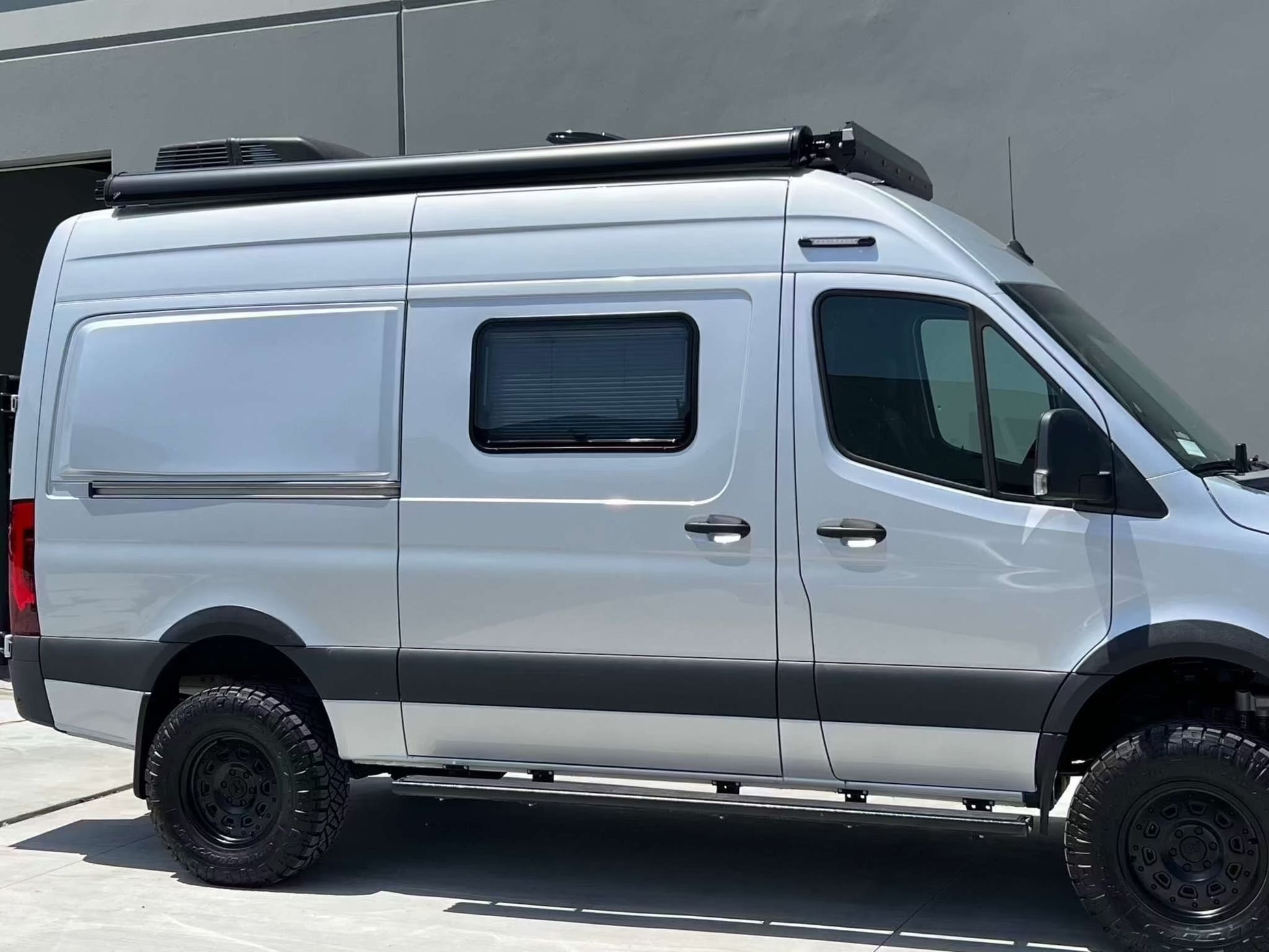Silver van equipped with black Super Single Spare Wheel designed for off-road use