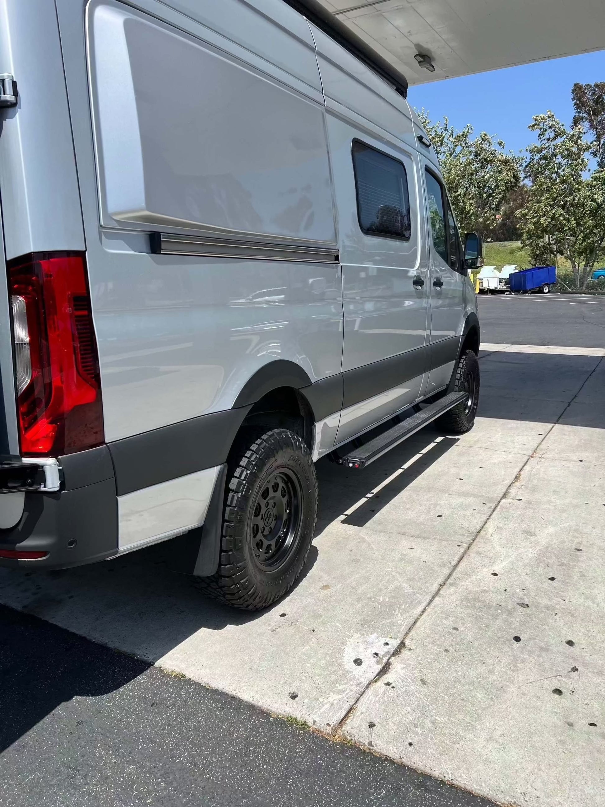 Super Single Spare Wheel installed on white off-road Sprinter van with matte black aggressive design