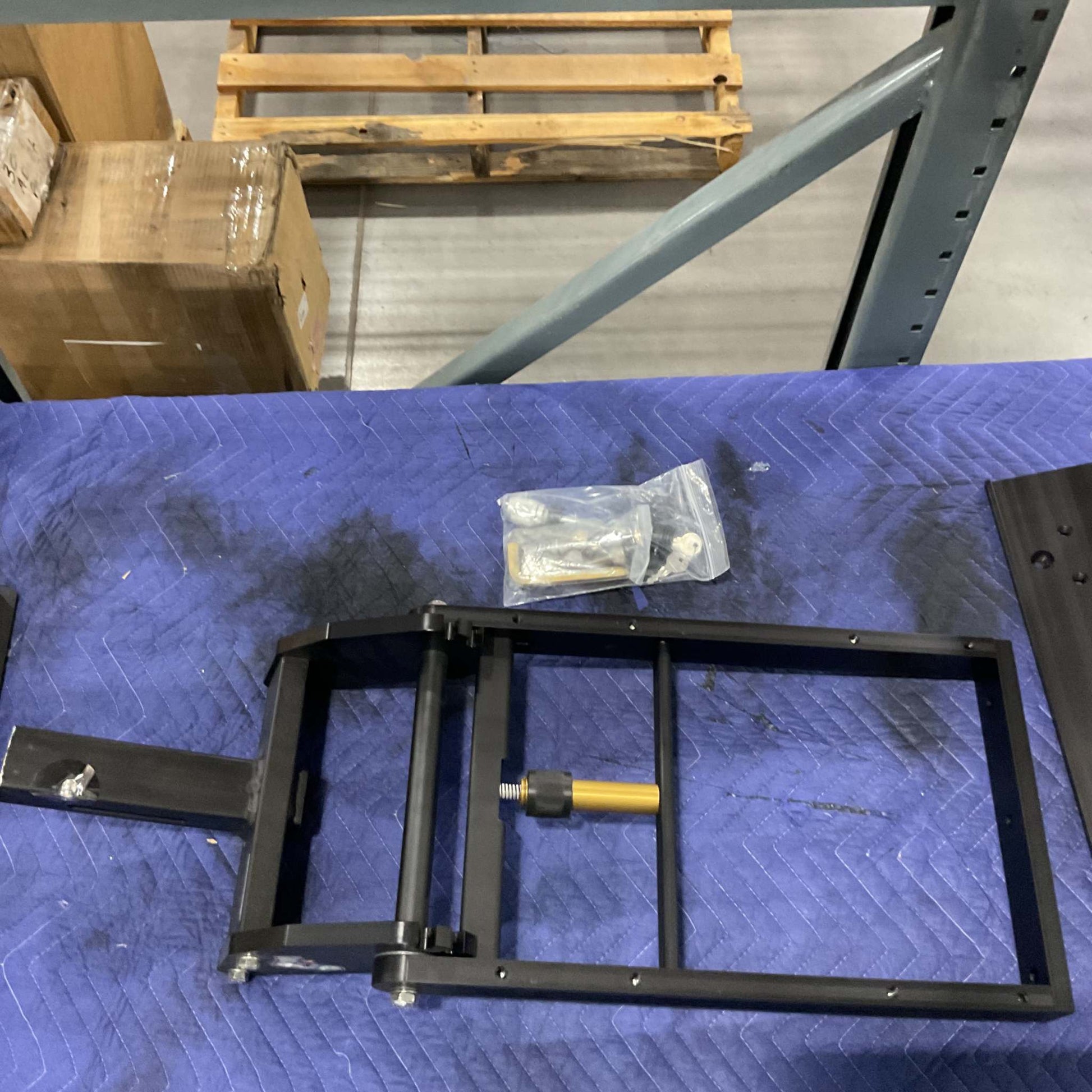 2" Super Duty Hitch double bike rack frame with hardware on blue padded surface in warehouse setting