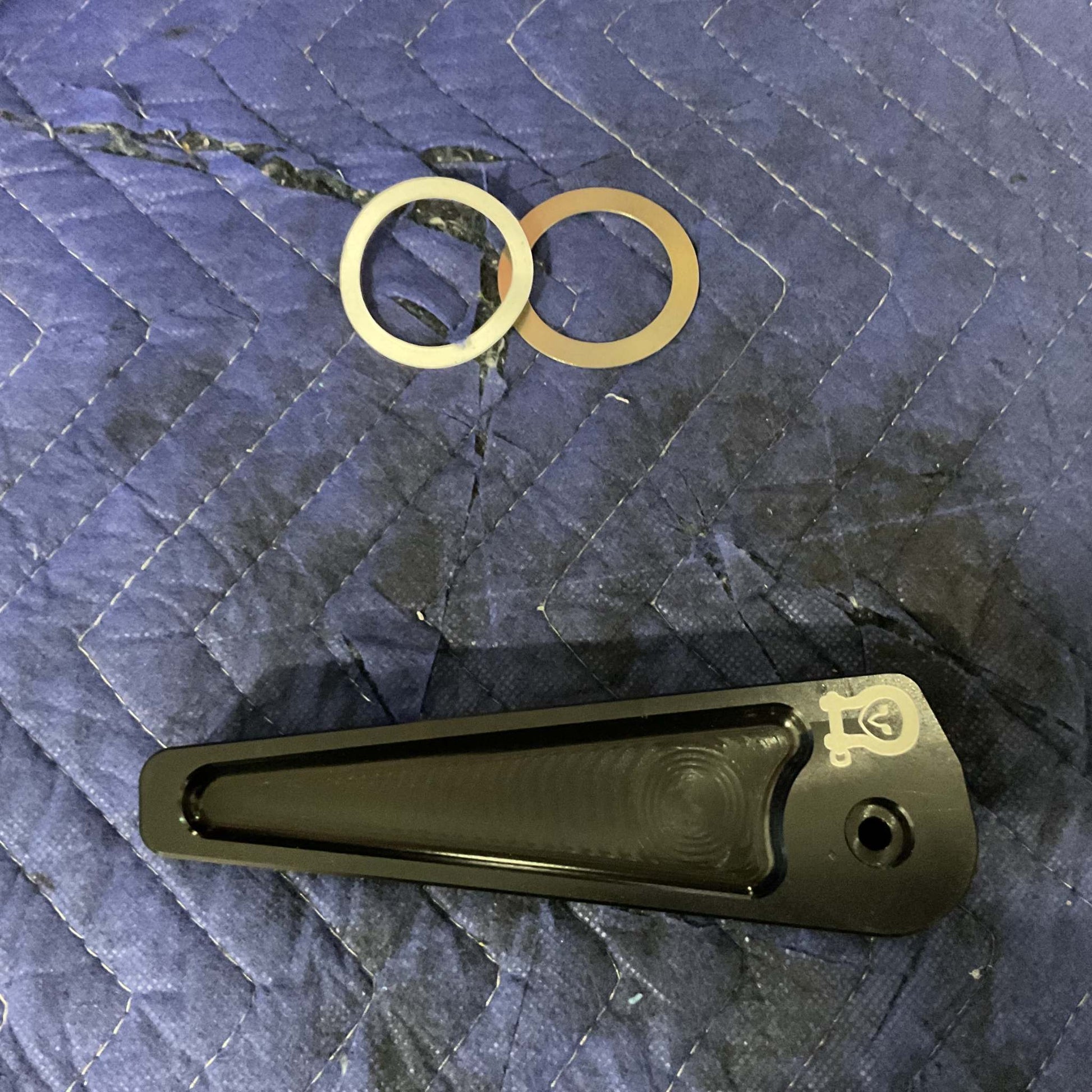 Grenadier Hood Release Handle with metal washers on a blue padded surface