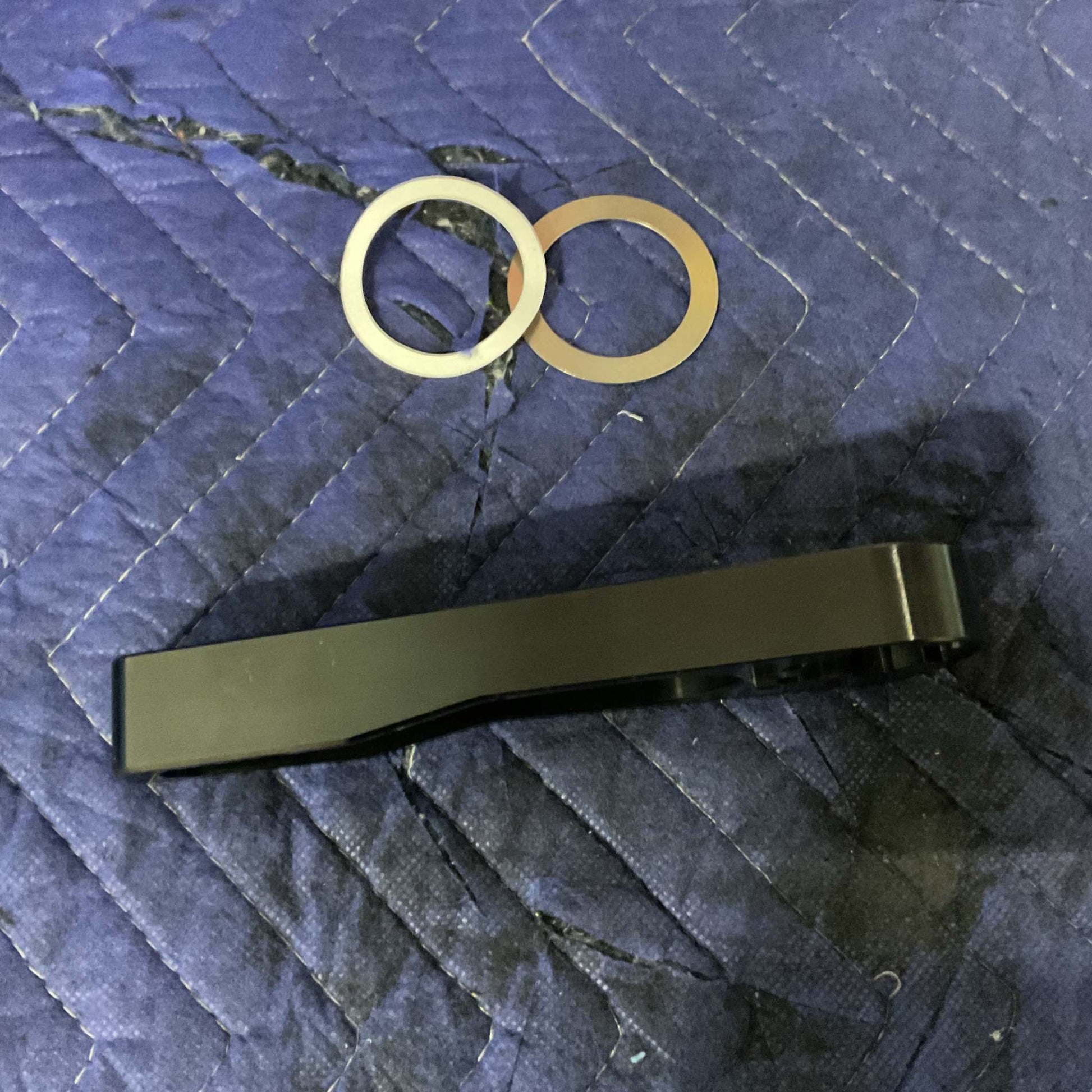 Grenadier Hood Release Handle black lever with two metal washers on blue quilted fabric