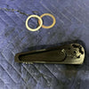 Black Grenadier Hood Release Handle with two metal washers on quilted fabric background