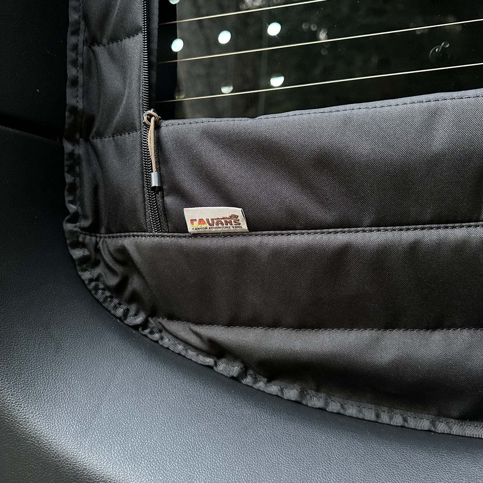 Close-up of black insulated Sprinter rear window cover with zipper for airflow and temperature control