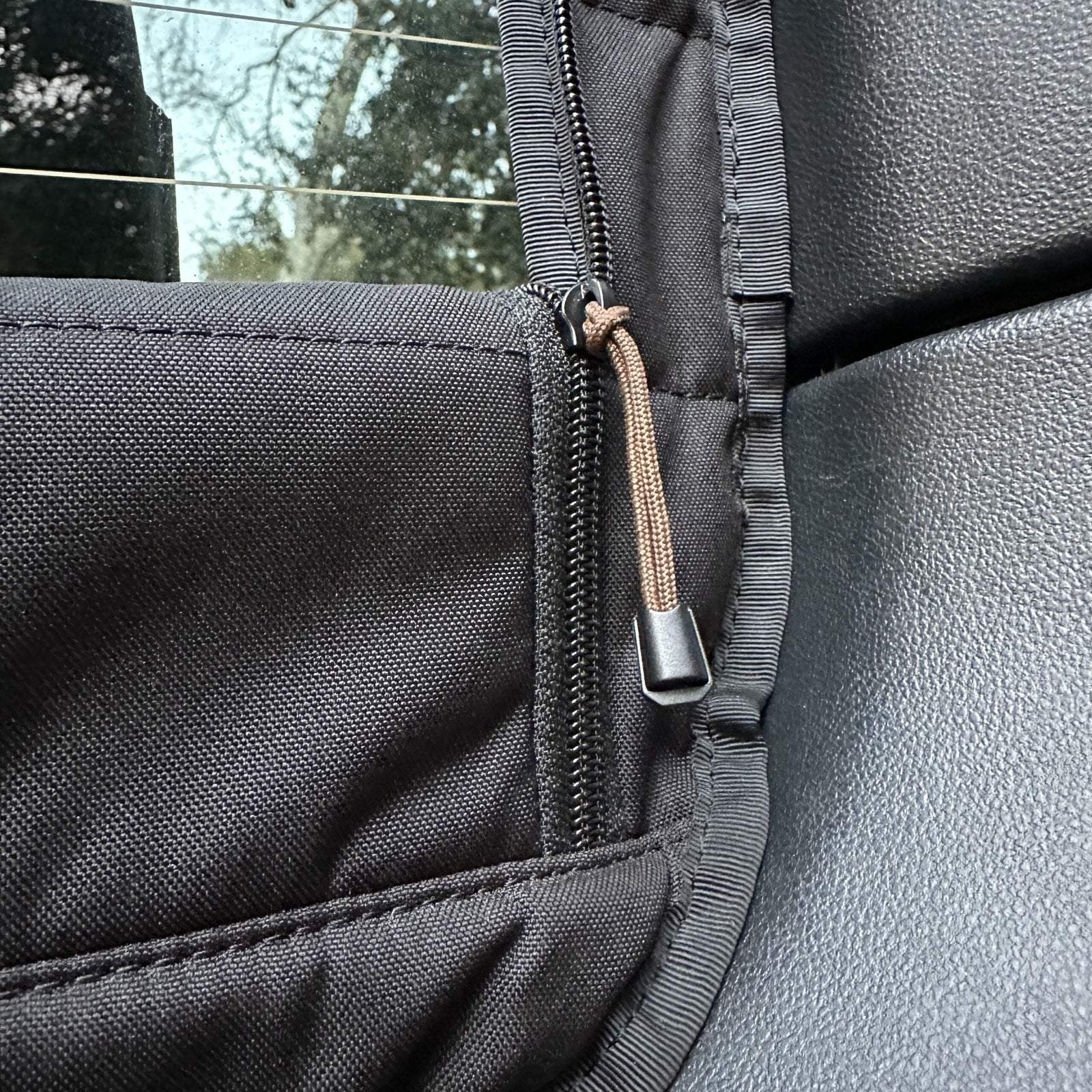 Close-up of black insulated Sprinter rear window cover with zipper for airflow and temperature control