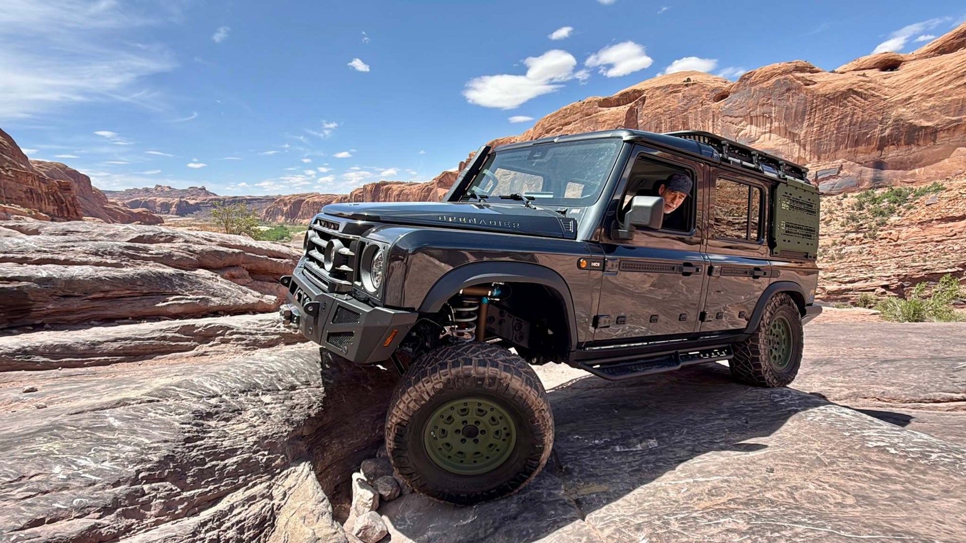 Owl Grenadier Steering Stabilizer installed on off-road Grenadier vehicle driving on rocky terrain