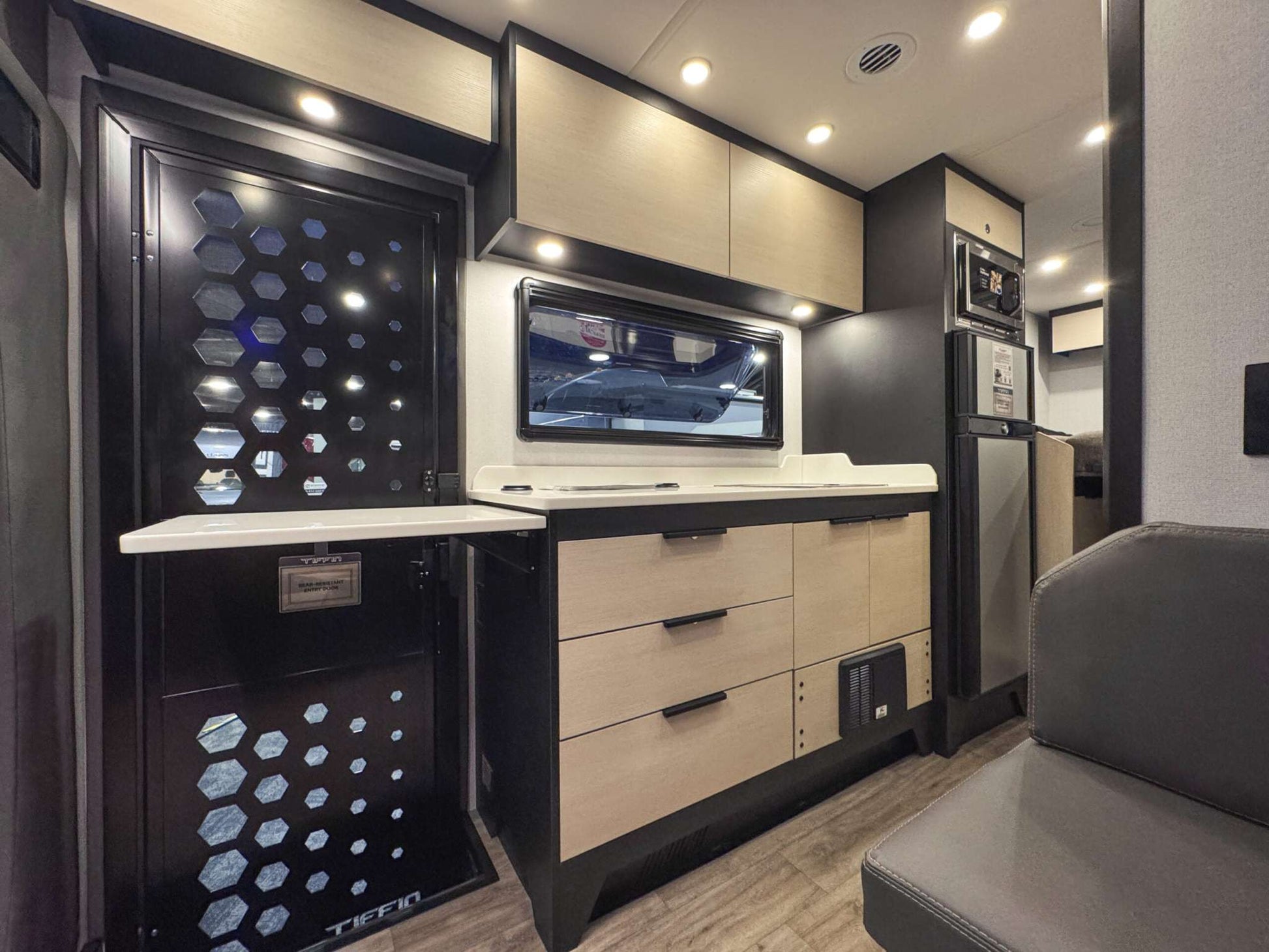 Interior kitchen area of OTX Tiffin motorhome with modern cabinetry and seating