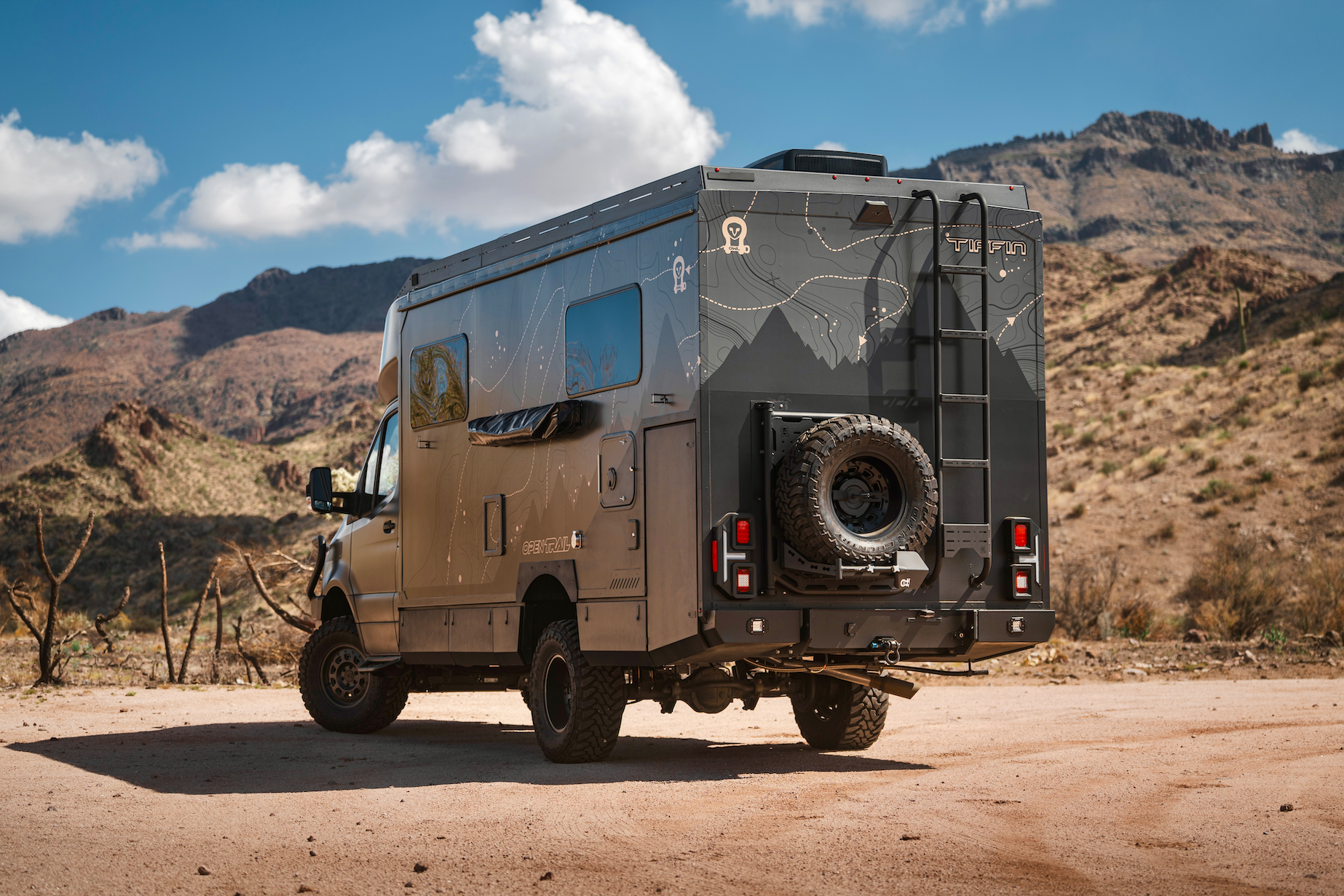 OTX Tiffin Open Trail adventure van parked in desert landscape with rugged mountains in background