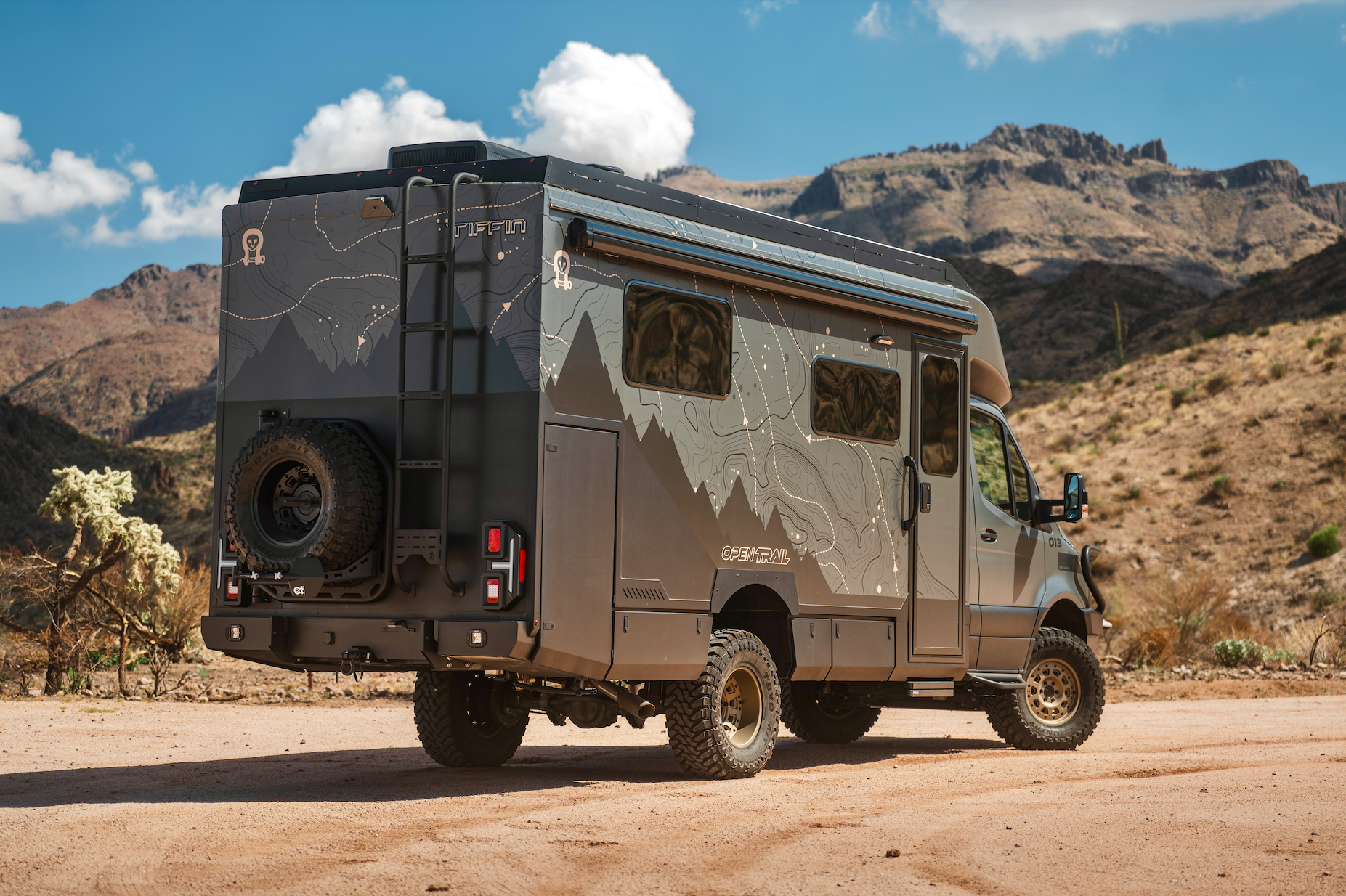OTX Tiffin Open Trail adventure van parked on a dirt road in a mountainous desert landscape