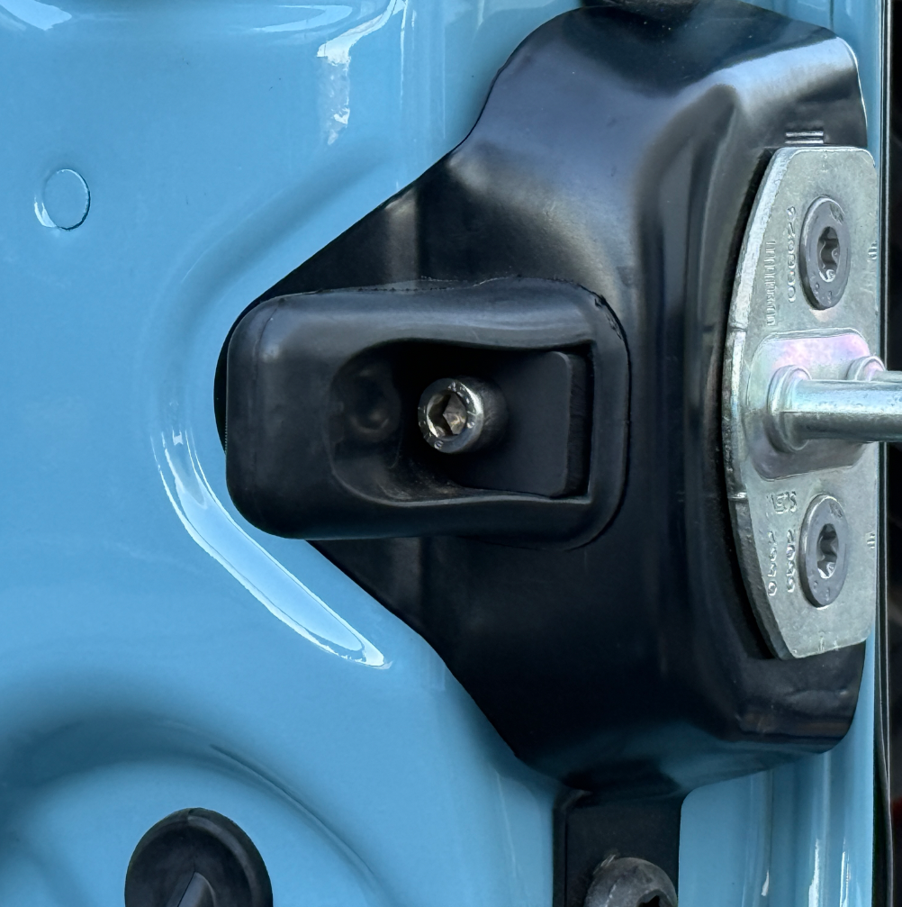 Close-up of rear door washer and bumper on a blue INEOS Grenadier vehicle door