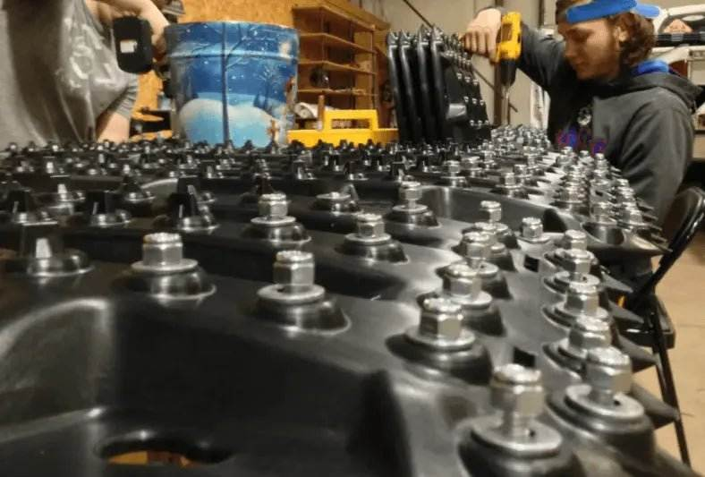 Steel Pin Traction Boards with high-strength polymer and embedded steel pins in an off-road setting.