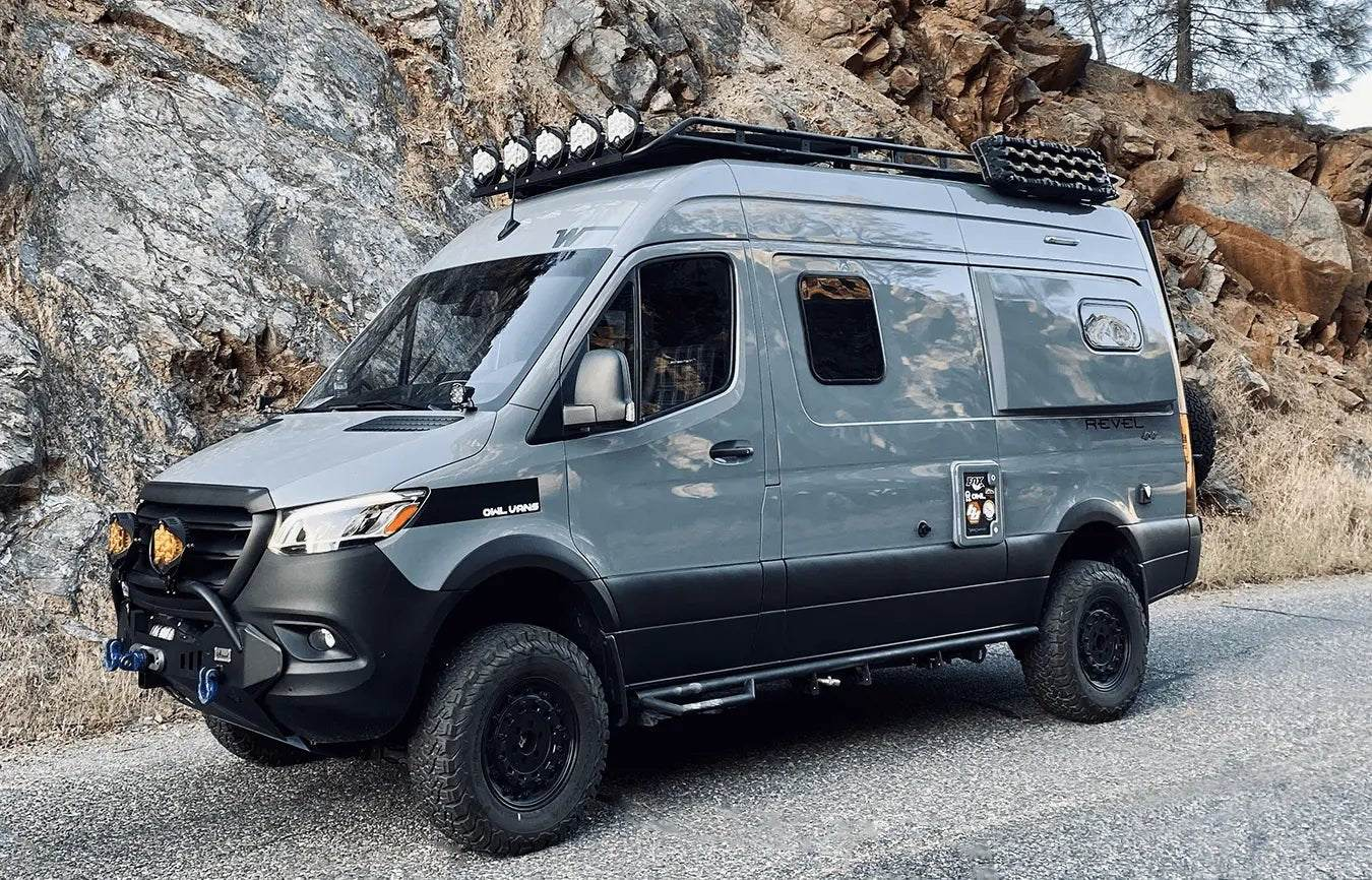 Gray off-road van equipped with LP9 Sport LED Light rooftop lamps parked on a mountain road