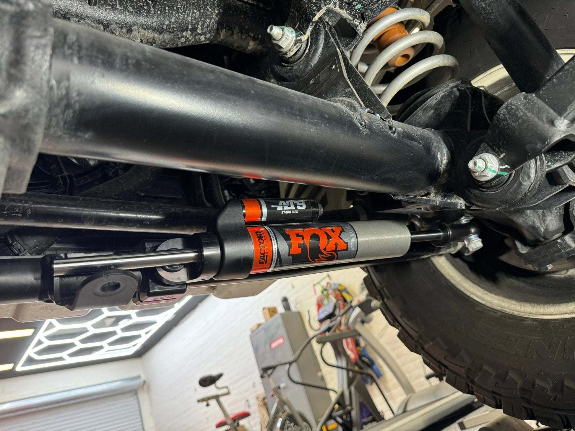 Fox Shocks Race Series 2.0 ATS Grenadier Steering Stabilizer installed on INEOS Grenadier, enhancing off-road performance.