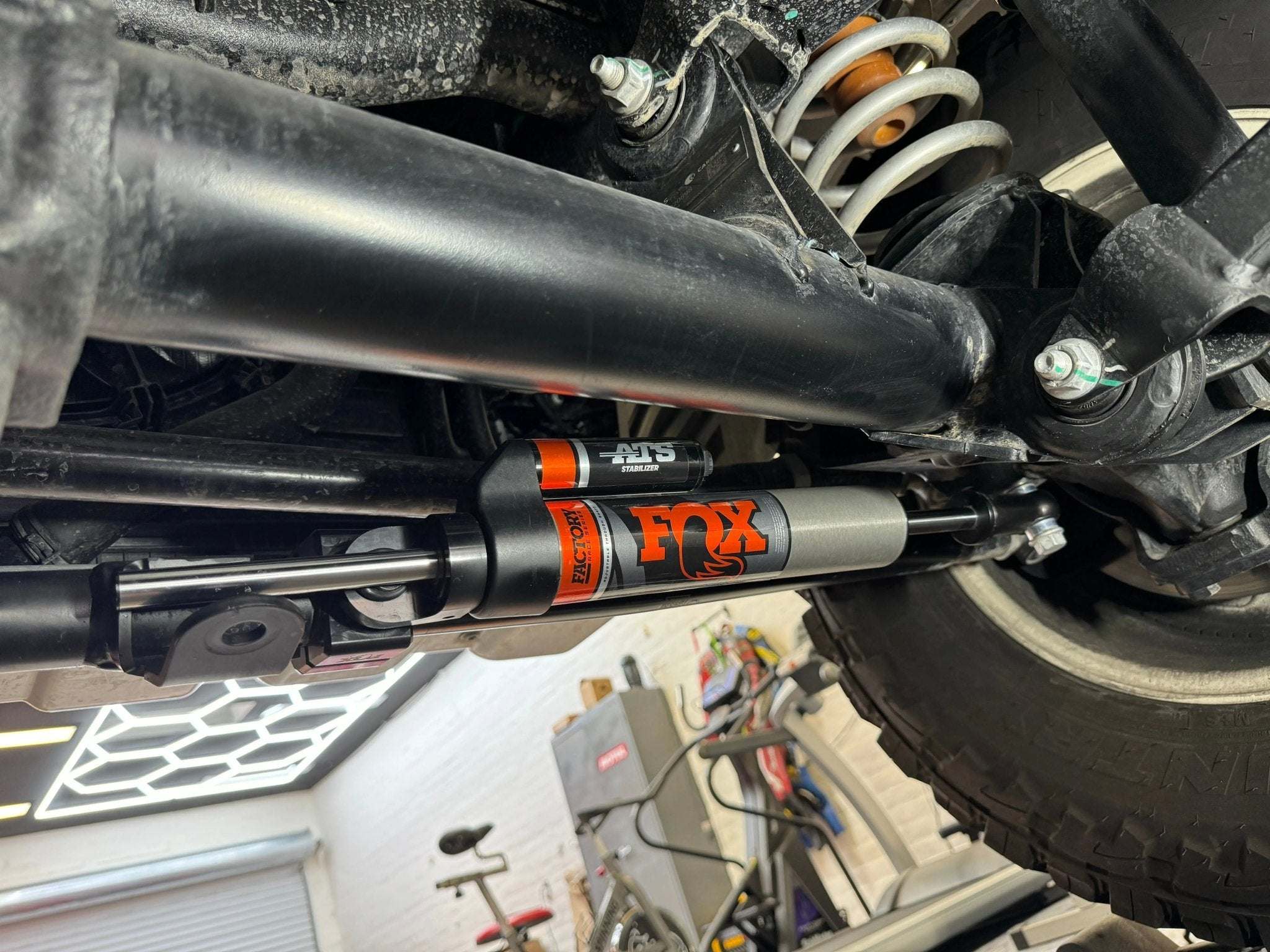 Fox Shocks Race Series 2.0 ATS Grenadier Steering Stabilizer installed on INEOS Grenadier, enhancing off-road performance.