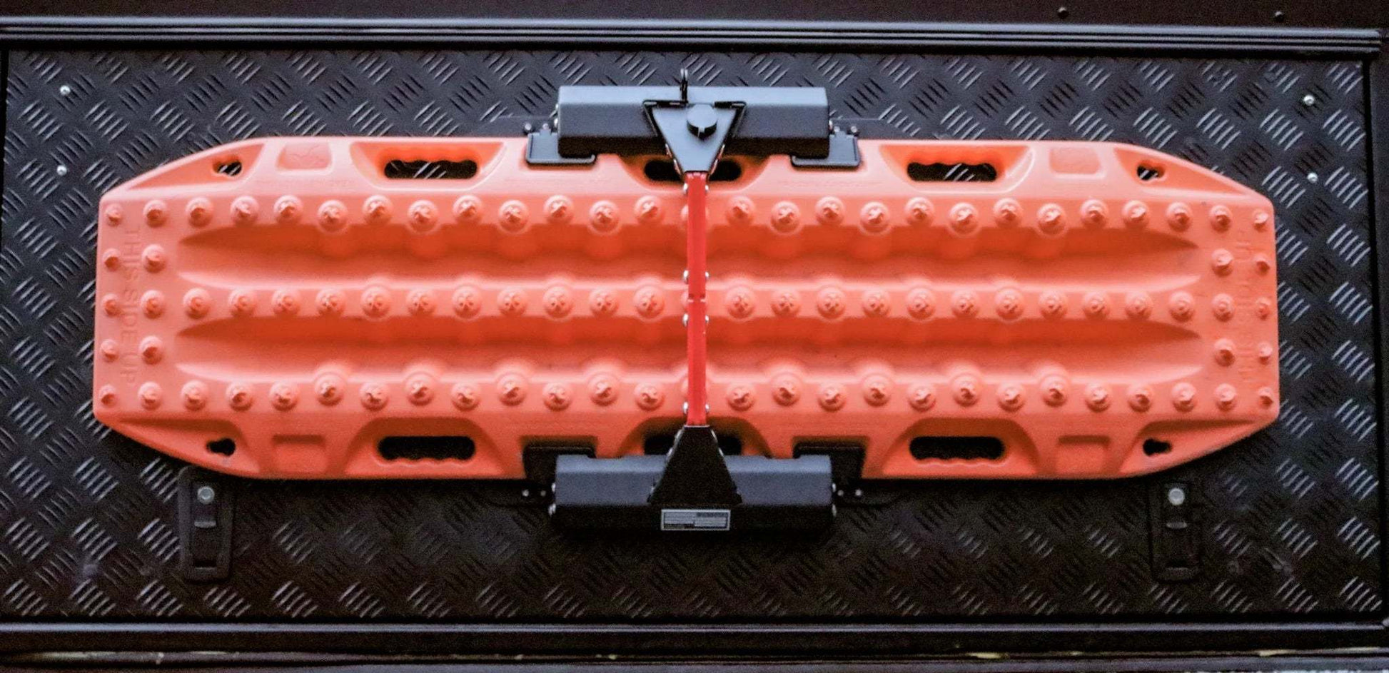 Maxtrax recovery board mounted on a locking quick release Maxtrax Mount on a textured black surface