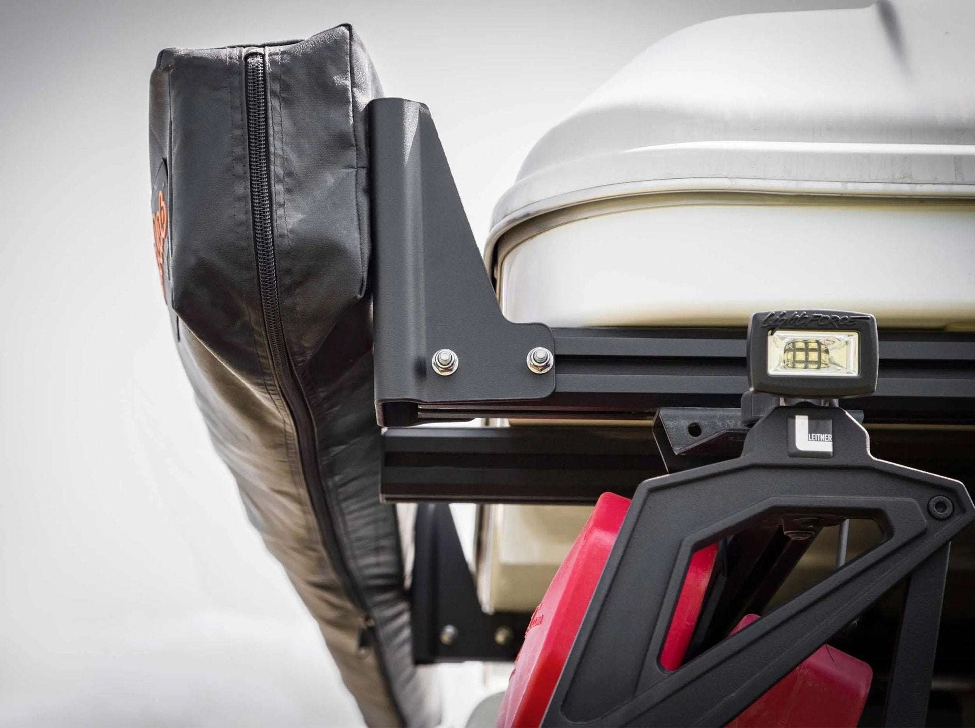 HD Awning Bracket attached to INEOS Grenadier roof rack system for expedition-grade support.