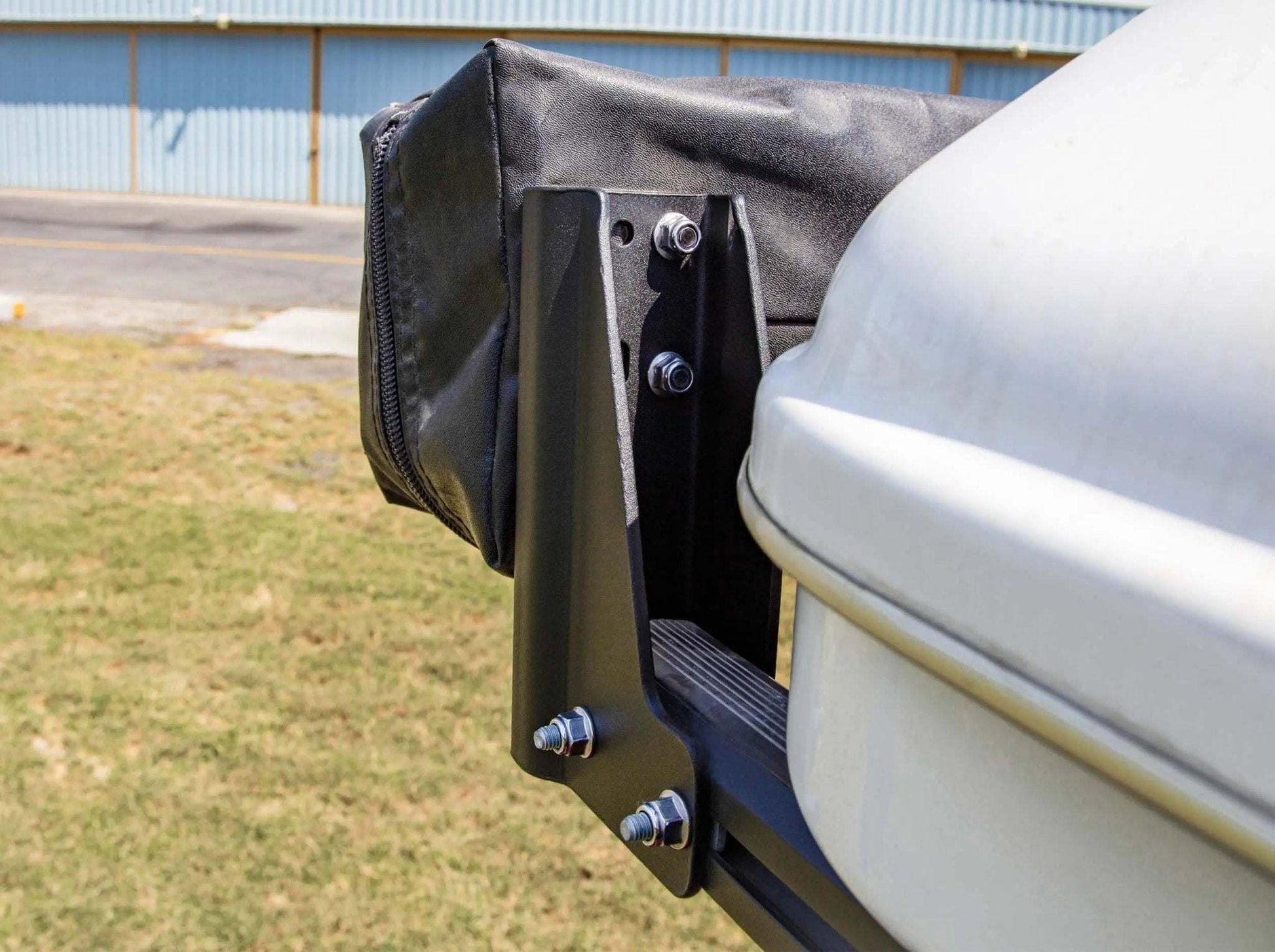HD Awning Bracket for INEOS Grenadier attached to a roof rack, showcasing its durable, expedition-grade construction.