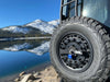 Weatherproof padlock securing spare tire in outdoor setting.