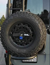Weatherproof padlock securing spare tire outdoors.