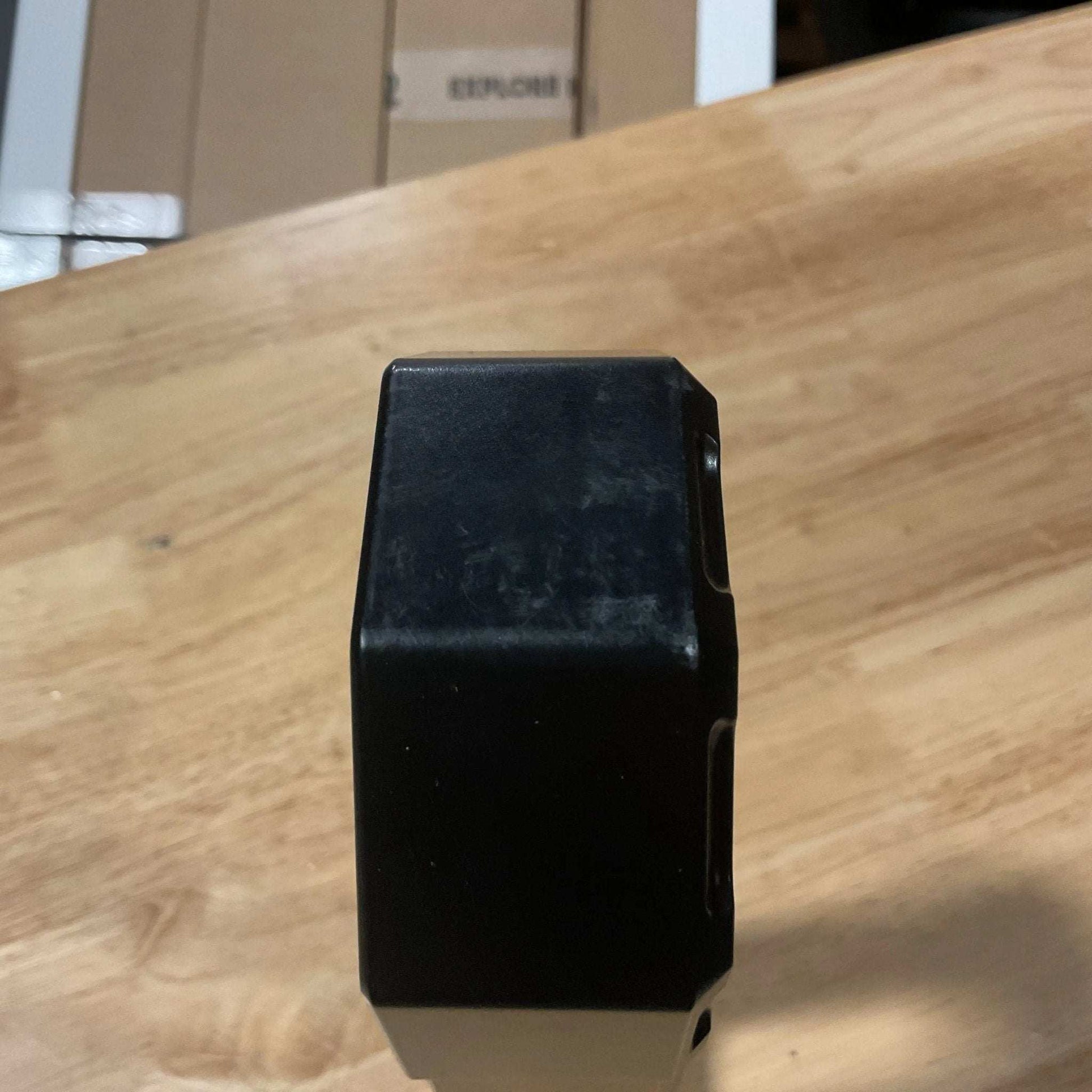 Black winch fairlead with minor scuffs on wooden surface, satin black finish.