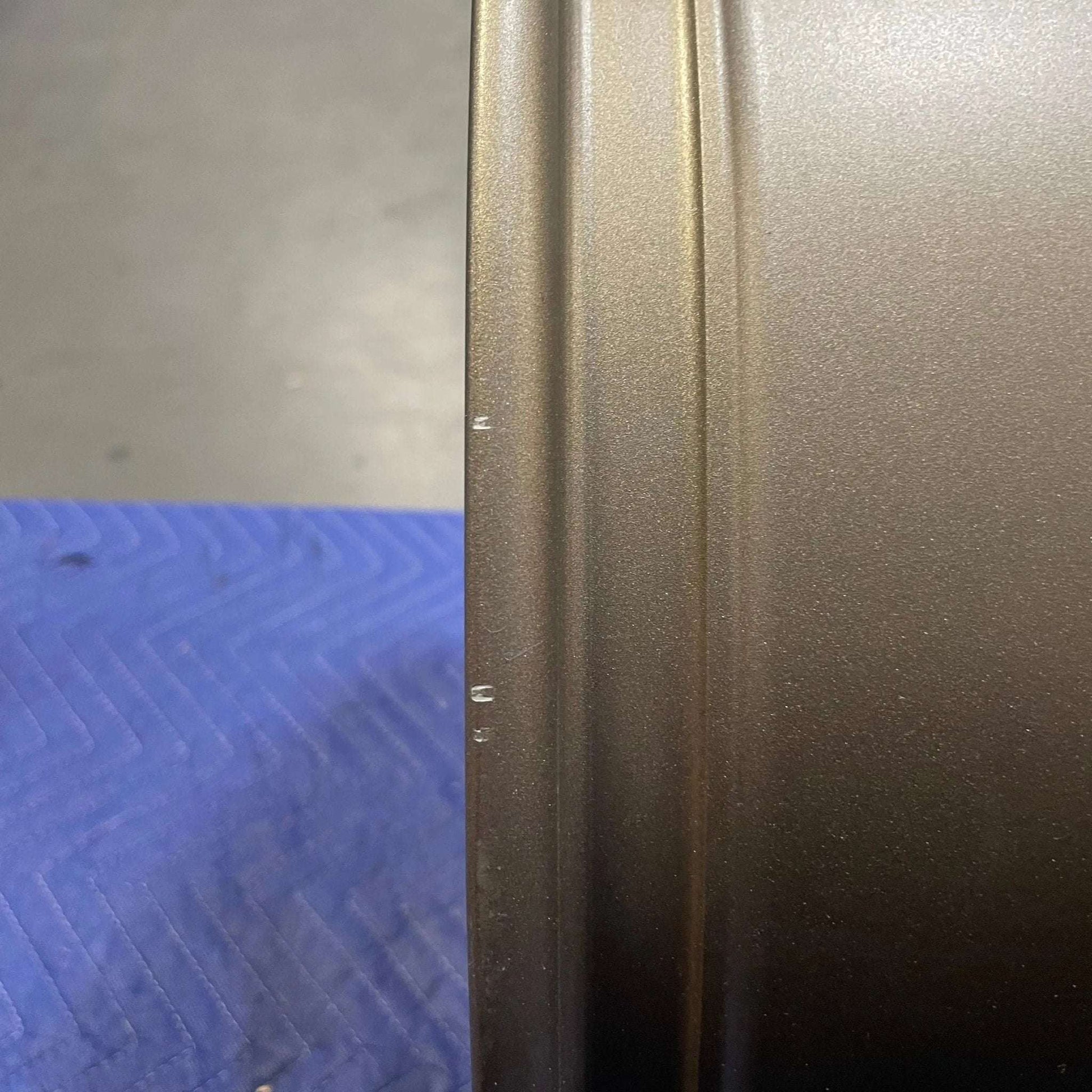 Close-up of bronze Owl Mojo Sprinter wheel rim with minor scuffs on a blue surface