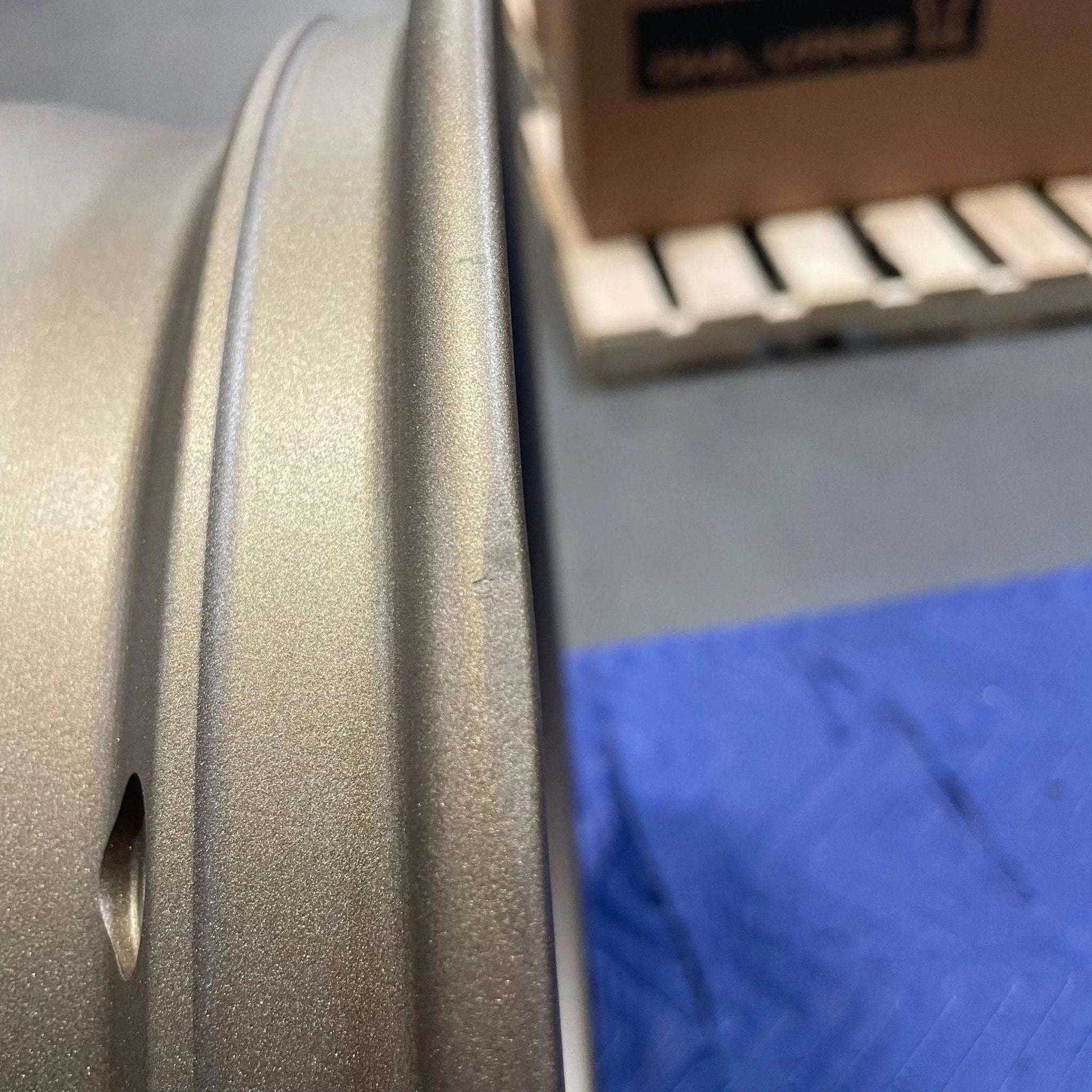 Close-up of an open box bronze Owl Mojo Sprinter wheel with minor scuffs and scratches on the rim surface