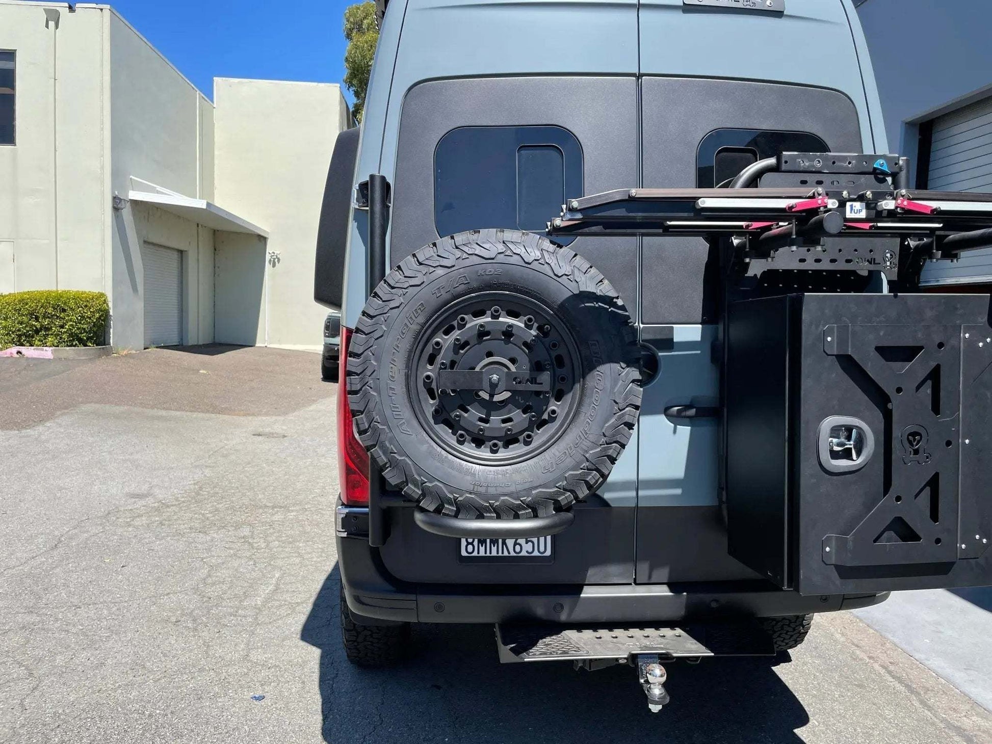 Expedition Tire Carrier on 2019+ Sprinter with mounted spare tire, showcasing durability and seamless gear integration.