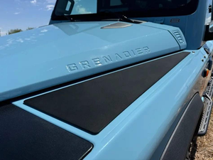 Blue INEOS Grenadier vehicle with black Grenadier Fender Armor plates installed on the fender for durability and off-road use.