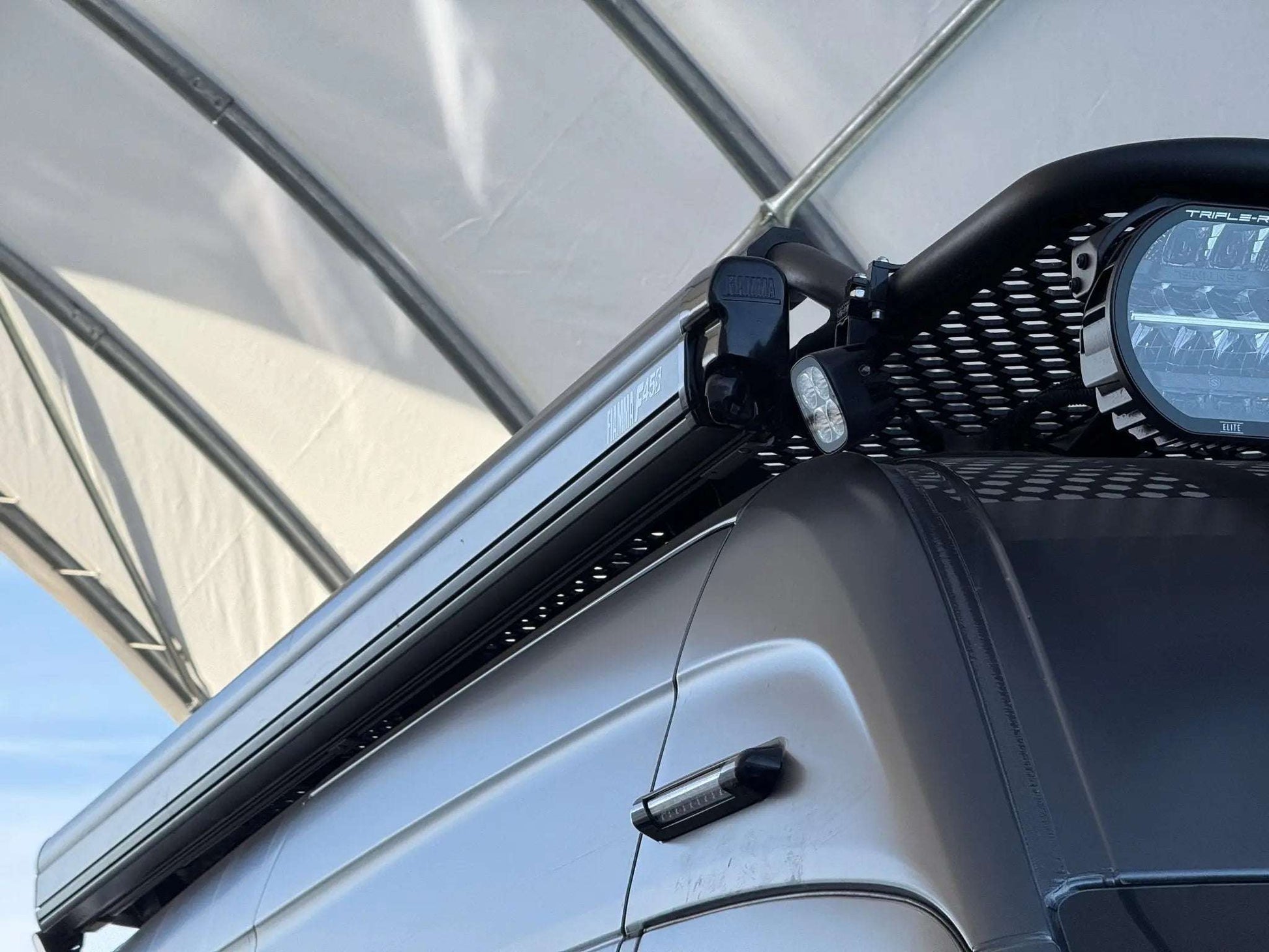 Fiamma roof rack with Sprinter awning mount and round bar mounts on van roof