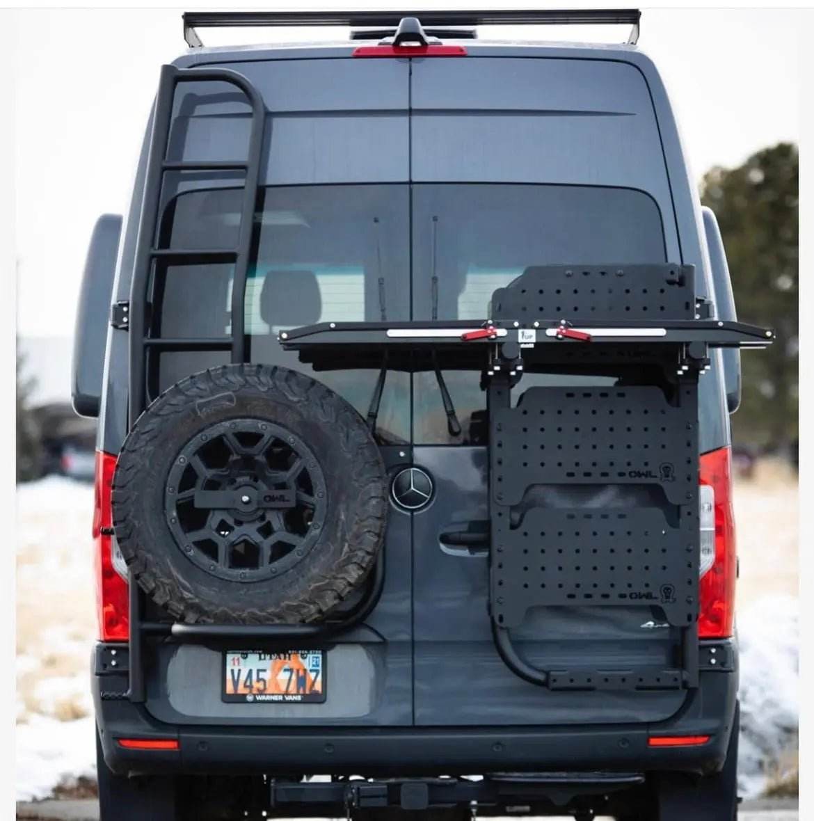Mini Sherpa Carrier installed on the back of a van with ladder and spare tire.