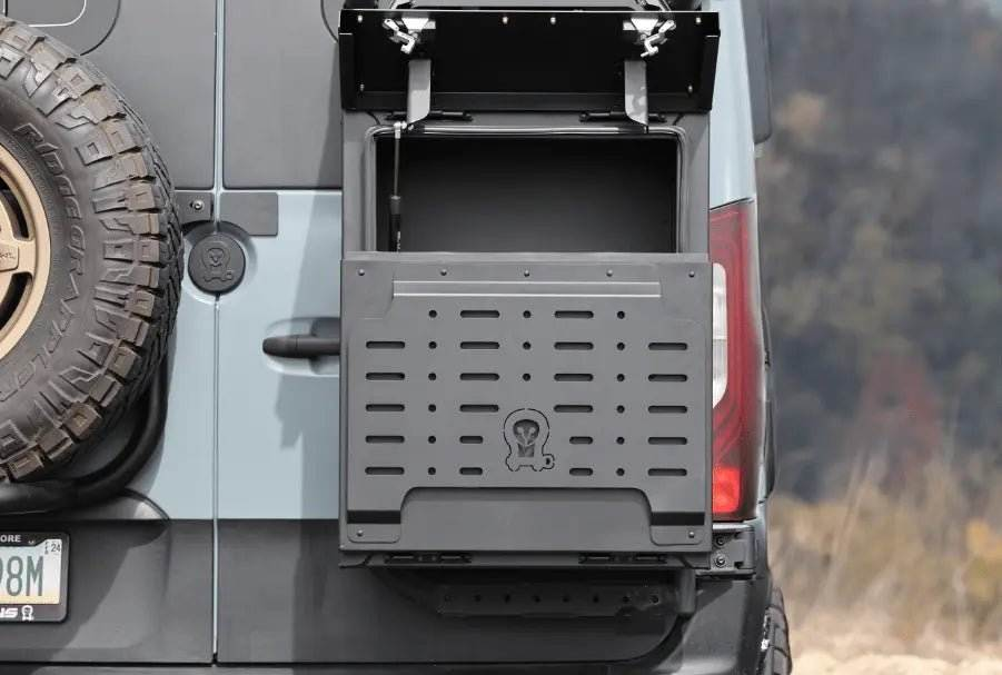 Metal van storage box mounted on vehicle rear with open lid and durable design