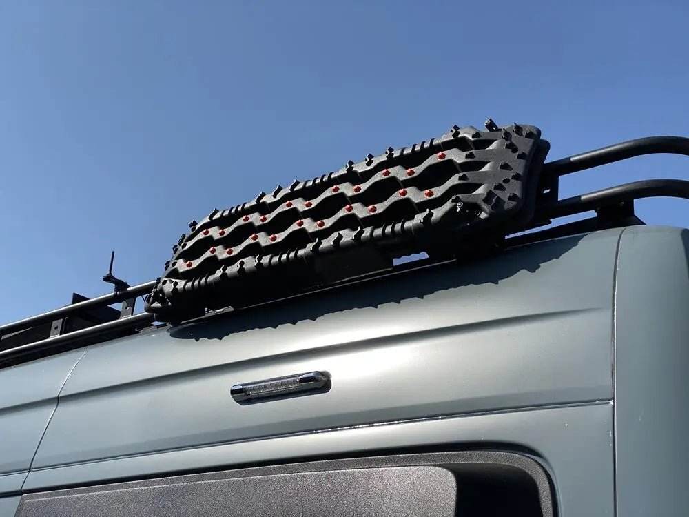 Roof rack traction board mount on vehicle for easy access to recovery gear.