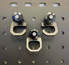 Three Sherpa Quick Release Hooks by Reeb Gear mounted on a perforated metal panel