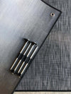 Small outdoor area rug with rugged texture and metal stakes, ideal for camping or van entryways.
