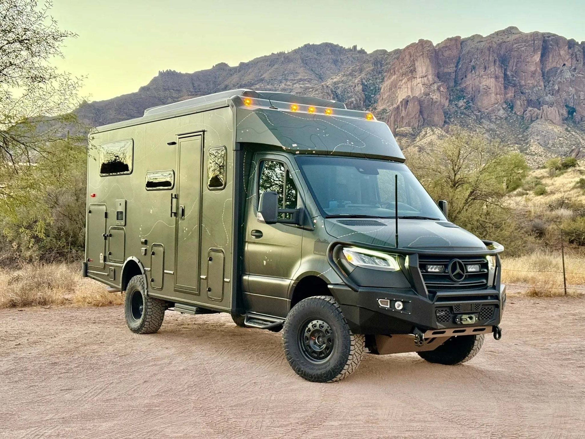 Sprinter van equipped with Talon Super Single off-road wheel set parked in desert landscape with mountains in background