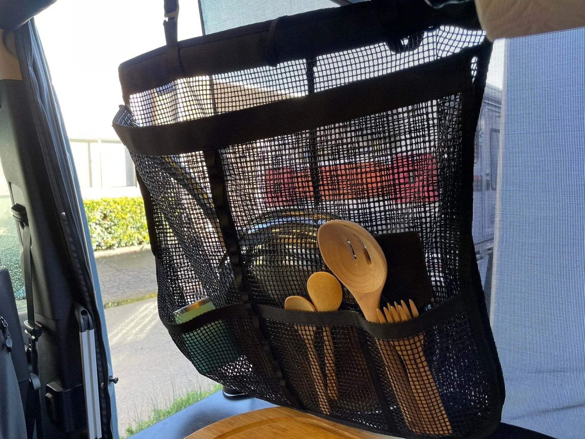 Camp Dish Drying Bag hanging with utensils, breathable mesh design.
