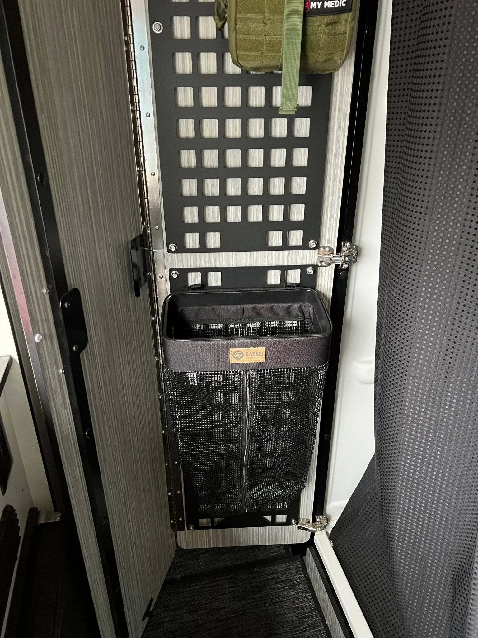 Camp seatback laundry bag mounted in camper van for organized, odor-free travel.