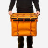 70L Storage Bag in orange, durable and designed for adventure, held by a person.