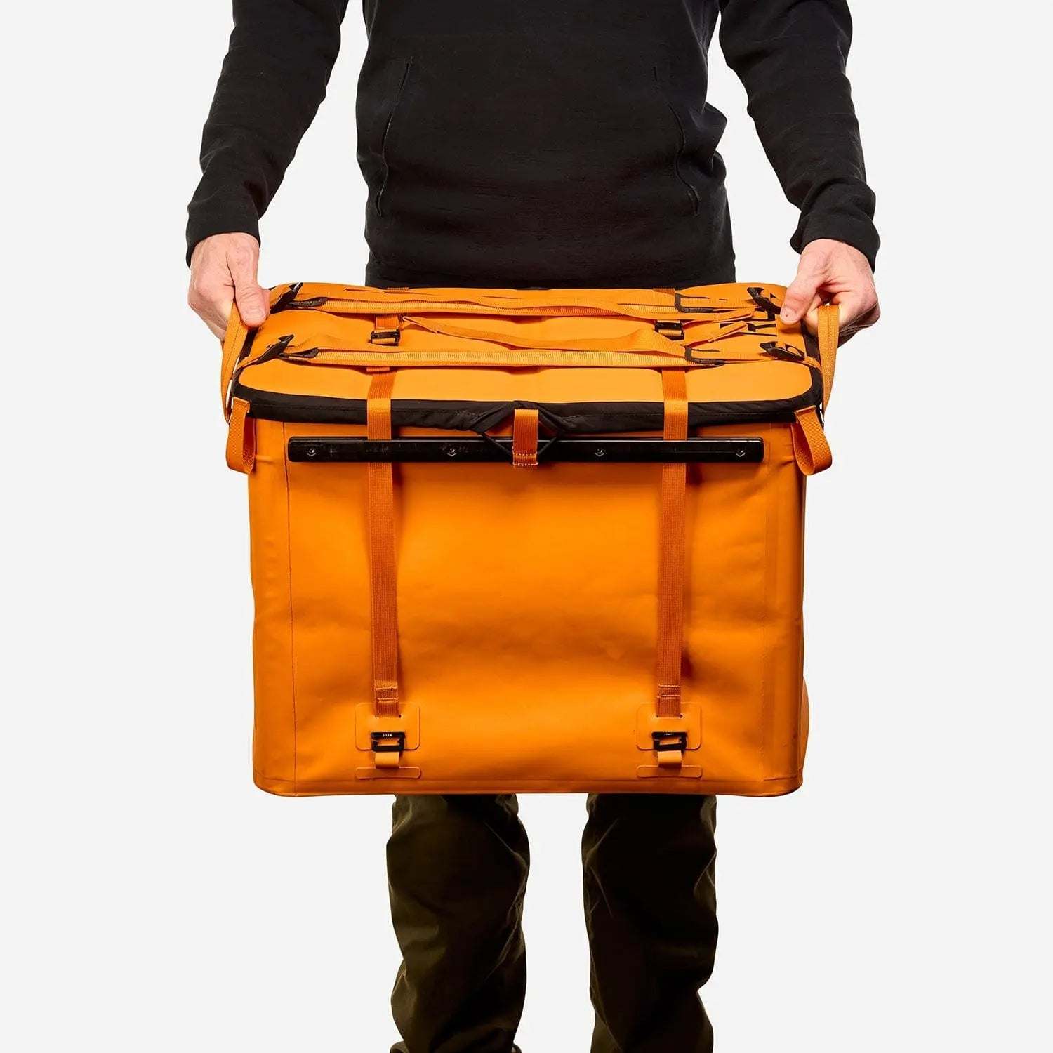 70L Storage Bag in orange, durable and designed for adventure, held by a person.