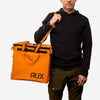 70L Storage Bag held by person, orange with RUX branding, designed for durability and adventure.