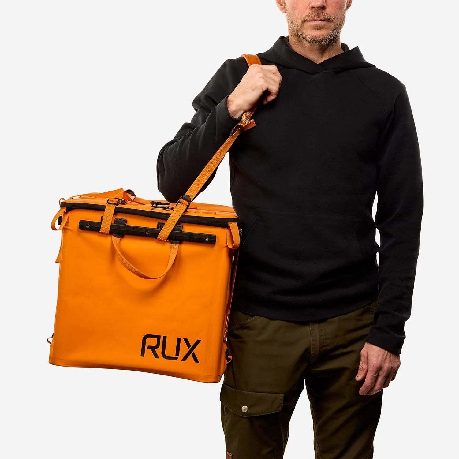 70L Storage Bag held by person, orange with RUX branding, designed for durability and adventure.