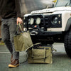 Essentials Set rugged adventure gear displayed in front of a Land Rover.